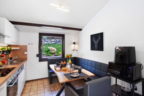 Una cocina compacta con comedor, microondas y cafetera.