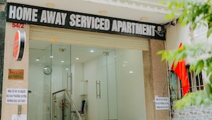 A serviced apartment building with a sign reading "HOME AWAY SERVICE APARTMENT."