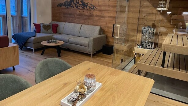 Een moderne woonkamer met een bank, salontafel en een eettafel.