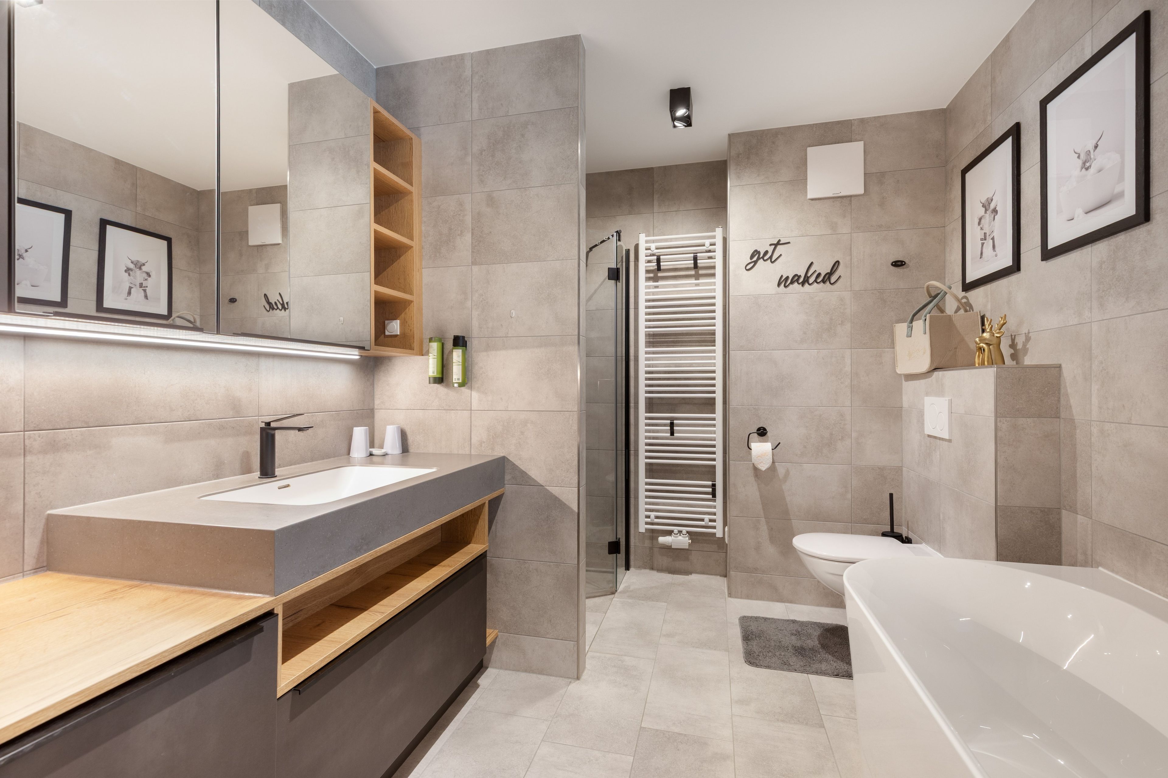 A modern bathroom with a bathtub, a shower, and a vanity with a mirror.
