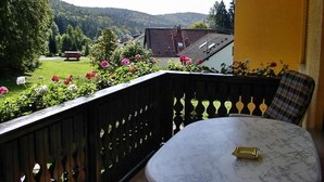 A balcony with a view of a green landscape and a house in the background. - Apartment 'Haus Moser - Fewo 1' with Valley View, Shared Terrace and Wi-Fi (Eschau)