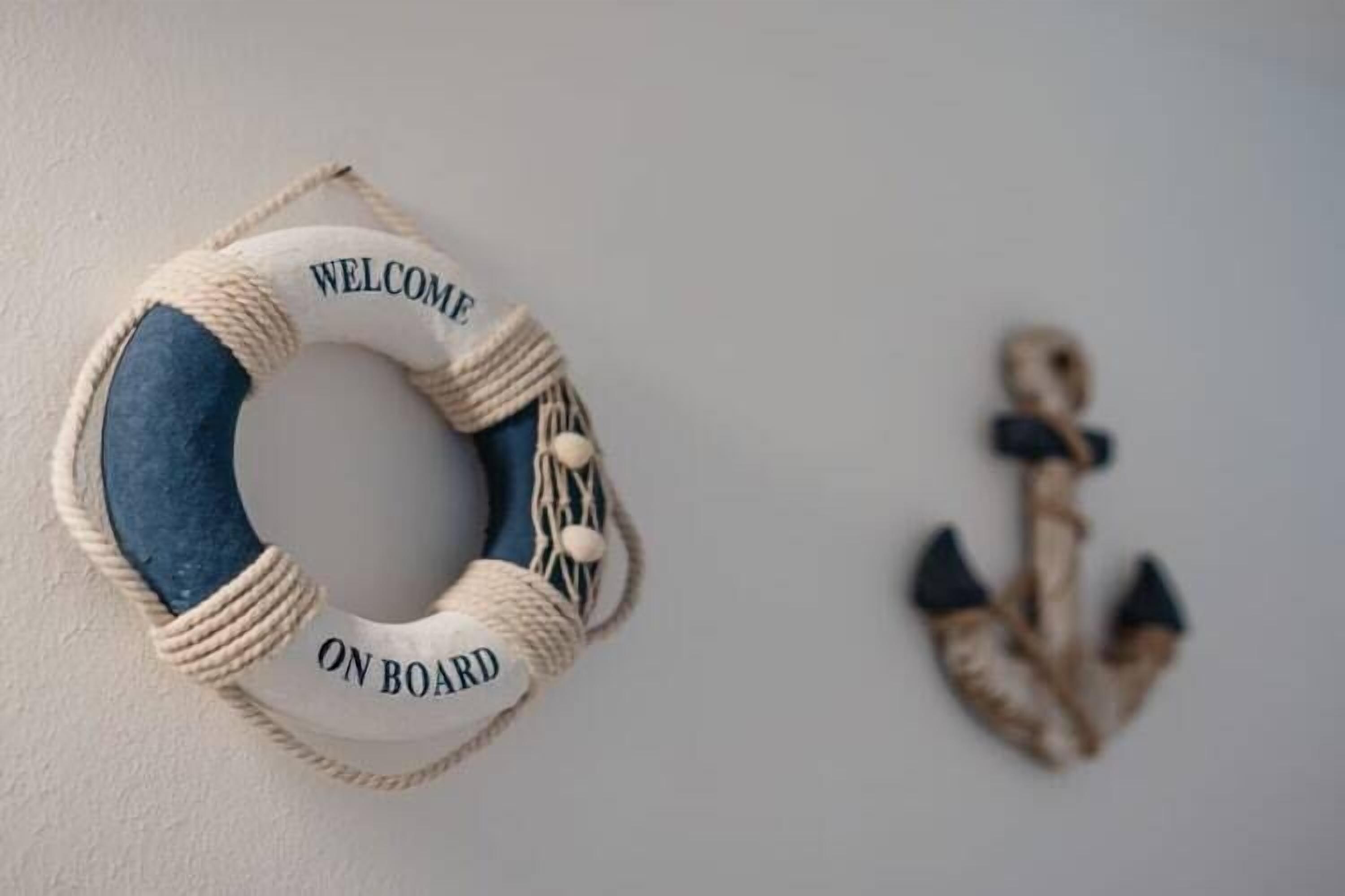 A life preserver with "WELCOME ON BOARD" text and a decorative anchor on a wall.