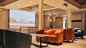 Un hall d’entrée moderne doté d’un grand écran, de sièges confortables et d’un intérieur propre et bien éclairé.