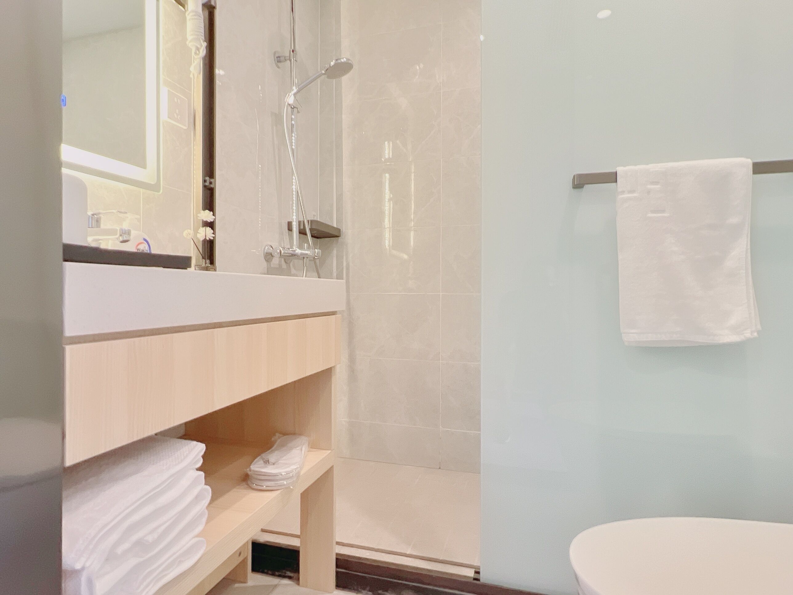 A modern bathroom with a shower, a toilet, and a sink area.