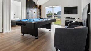 A modern room with a pool table, a seating area, and a large window offering a view of the outdoors. - "Henke" - 475m from the sea by Interhome (Ålbæk)