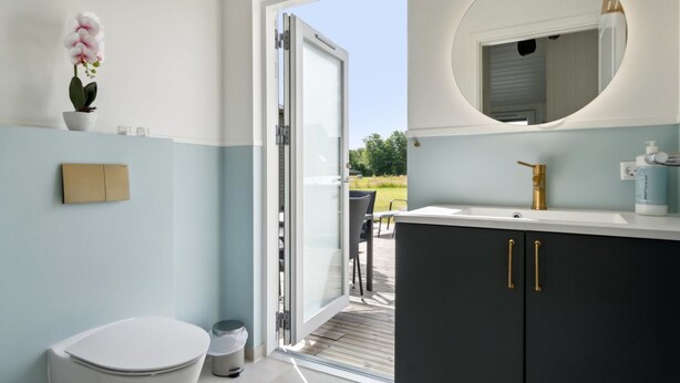 Ein modernes Badezimmer mit Toilette, Waschbecken und Spiegel.