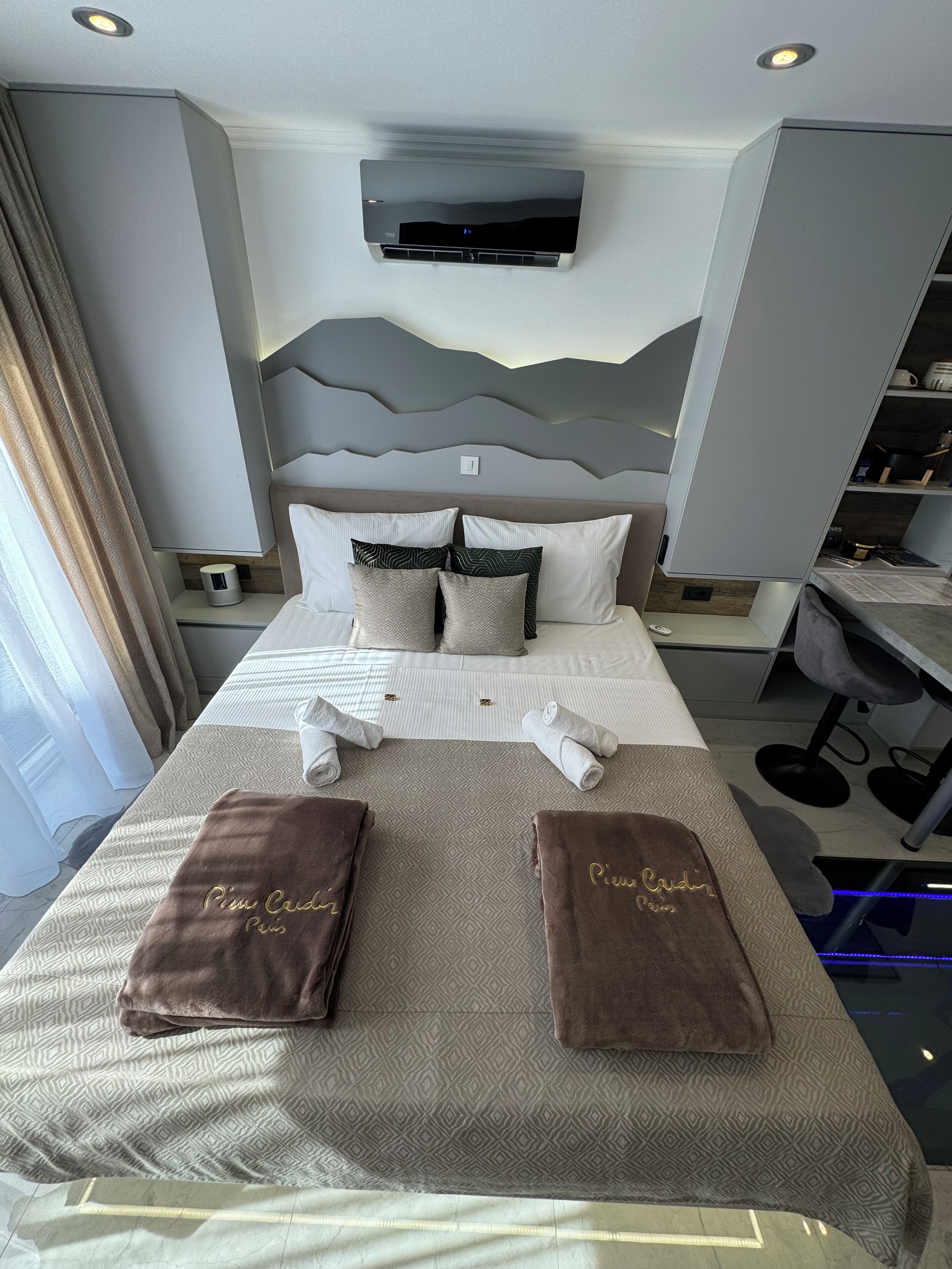 Une chambre d’hôtel moderne, équipée d’un lit, d’un bureau et d’une chaise.