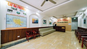 Un área de recepción con un mapa, un sofá y sillas de madera.