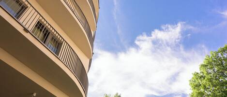 A multi-story building with balconies and a clear sky.