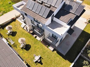 A modern building with solar panels, a balcony, and outdoor seating. - Atli Apart (Fethiye)