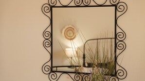 A mirror with a decorative black frame mounted on a wall.