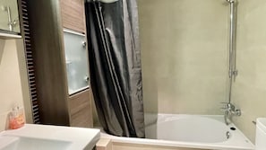 Un baño con bañera, ducha y retrete.