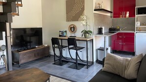 A modern living room with a TV, dining table, chairs, and a sofa. - Cosy sur Ourcq (TROESNES)