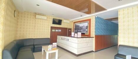 A reception area with a reception desk, a sofa, and a small table.
