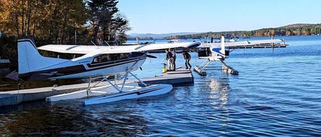 A lake with two seaplanes docked on floating platforms.