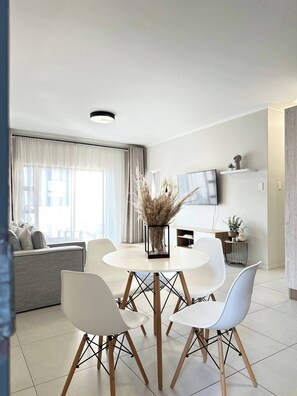Cozy living space with a round dining table and comfortable seating for four, perfect for relaxing and socializing.