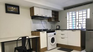 Eine kleine Küche mit Waschmaschine, Herd und Kühlschrank.