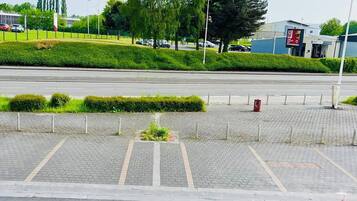 A parking lot with a flag, paved walkways, and a building in the background.