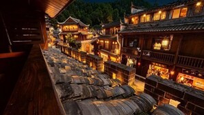 Ein traditionelles Holzgebäude mit mehreren Ebenen und einem Steinweg.