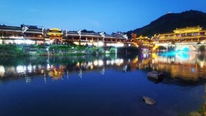 A traditional building with multiple levels and a reflection in the water.