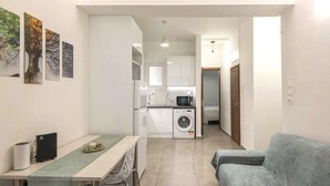 A compact living space with a dining area, kitchenette, and a sofa. - Sweet apartment in Athens A3 (Athina)