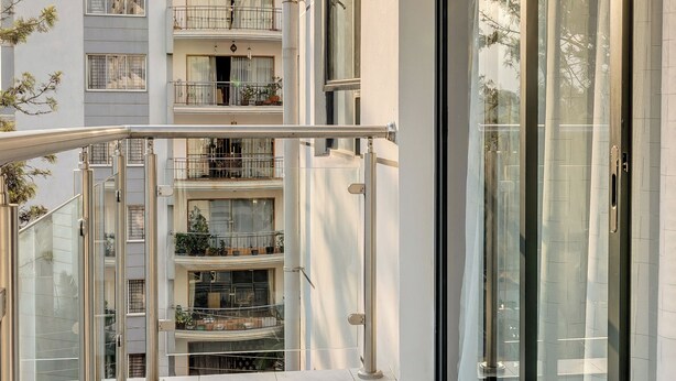 A modern apartment with a balcony, large windows, and a tiled floor. - Affordable Spectacular Urban Stays (Nairobi)
