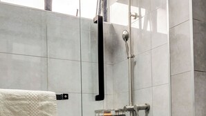A modern bathroom with a glass-enclosed shower, a white toilet, and a towel rack. - Affordable Spectacular Urban Stays (Nairobi)