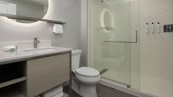 Ein modernes Badezimmer mit Toilette, Waschbecken und Dusche.