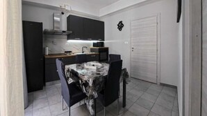 A compact kitchen with dark cabinets, a built-in microwave, and a stainless steel range hood. - GIORGIA'S HOUSE - VACATION HOME (Catania)