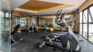 Uma academia com esteiras, elípticos e equipamentos de musculação.