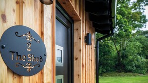 A wooden exterior with a door and a sign reading "2 The Shed". - The Shed - 1 Bedroom - Cosheston (Pembroke)