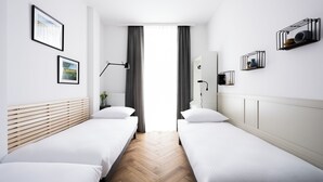 A hotel room with two single beds, a wooden headboard, a bedside table, a mirror, and a window with curtains. - Native Apartments Pułaskiego 6 (Kraków)