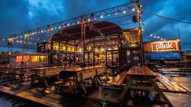Ein Restaurant am Wasserufer mit Außenbereich und Lichterketten.