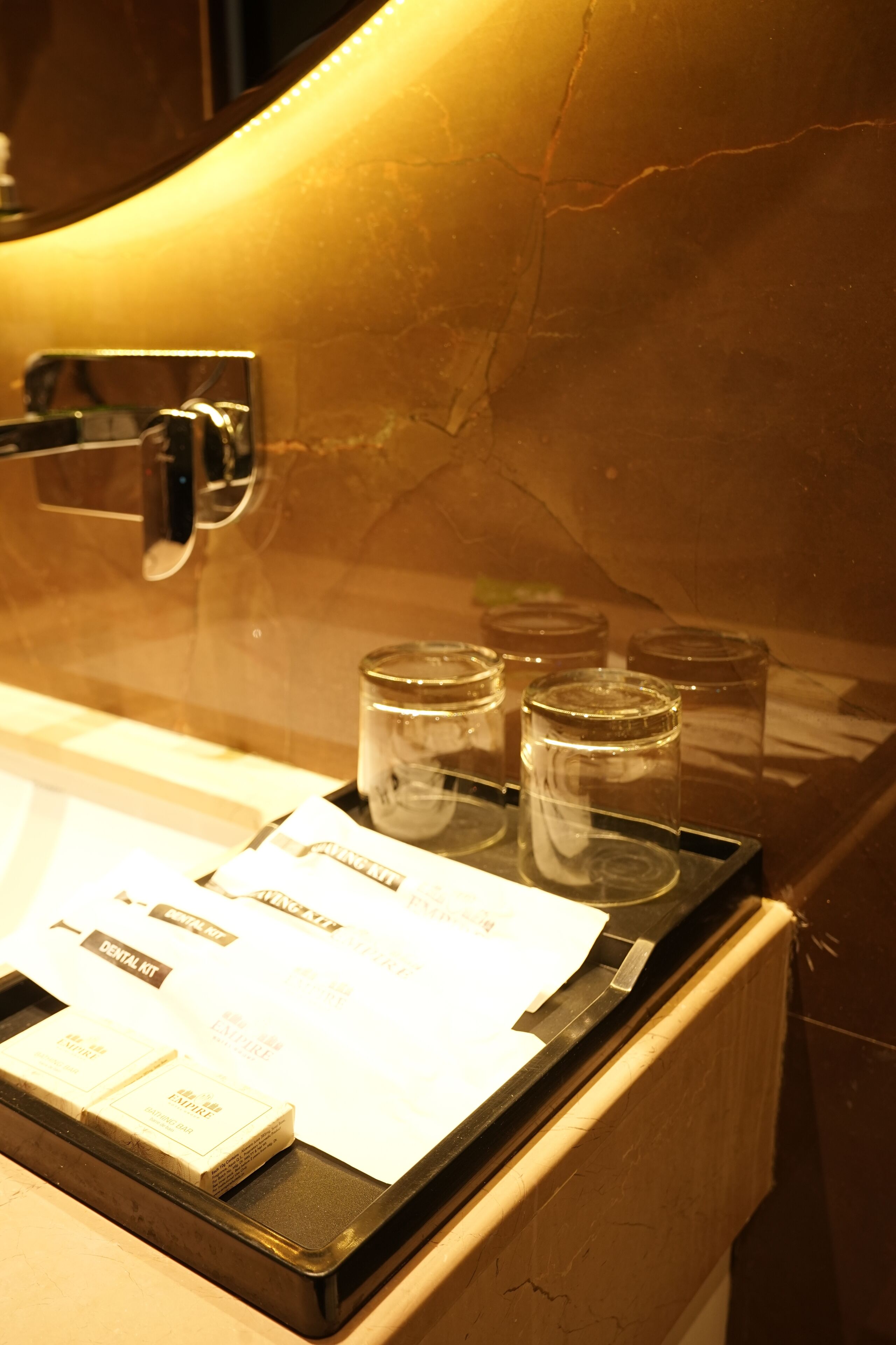 A tray with a menu and glasses on a marble countertop.