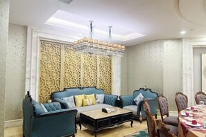A room with a sofa set, a coffee table, and a dining table with chairs.