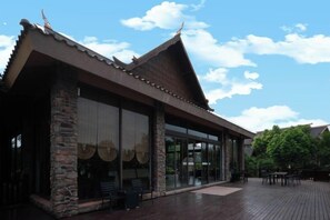 A building with a traditional architectural style, featuring a sloped roof and stone pillars.