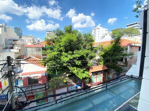 A residential area with a tree in the foreground, buildings in the background, and a clear blue sky. - Home Away Minh Khai (Ho Chi Minh City)