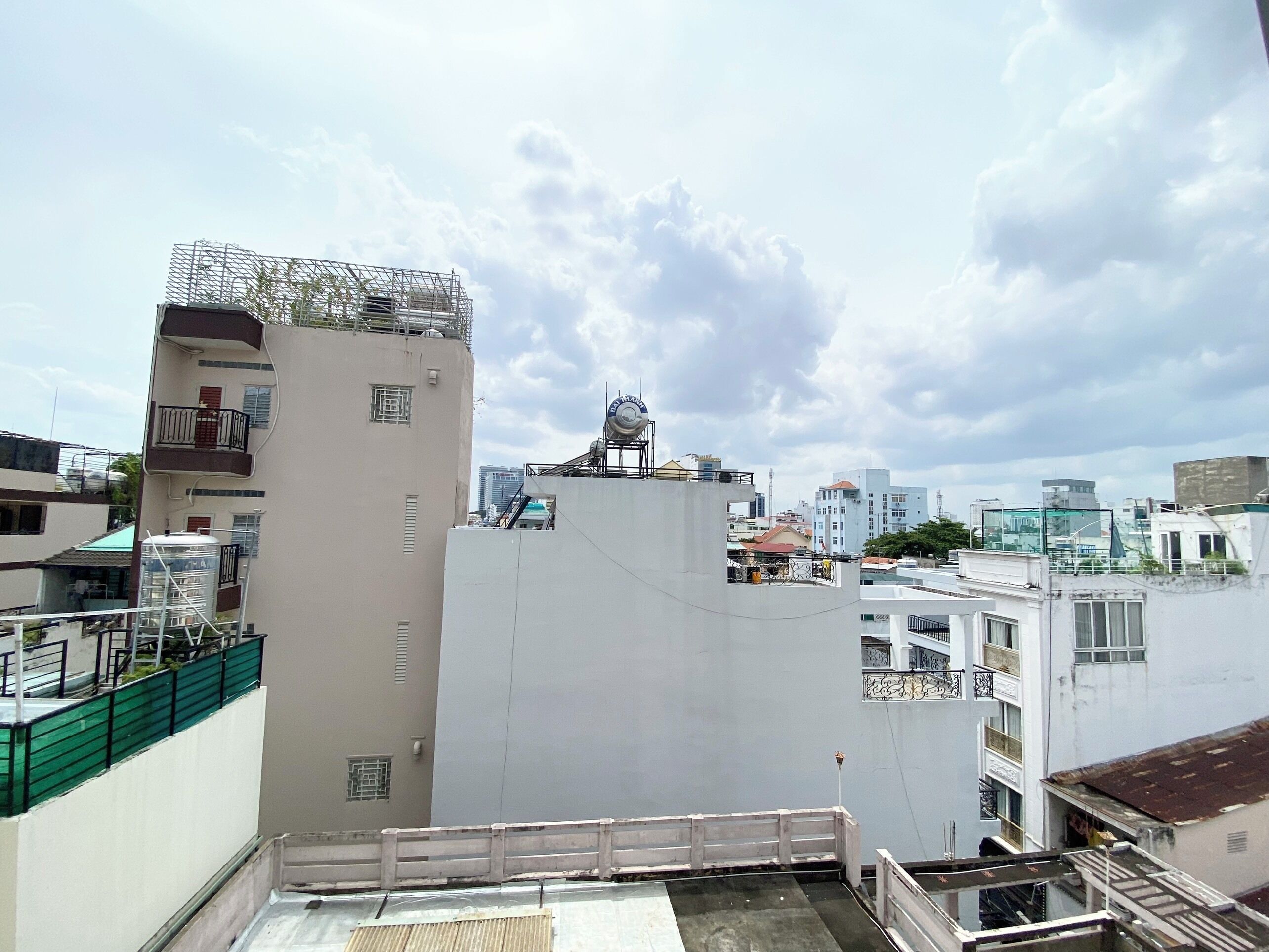 A high-rise building with multiple balconies and a rooftop water tank.