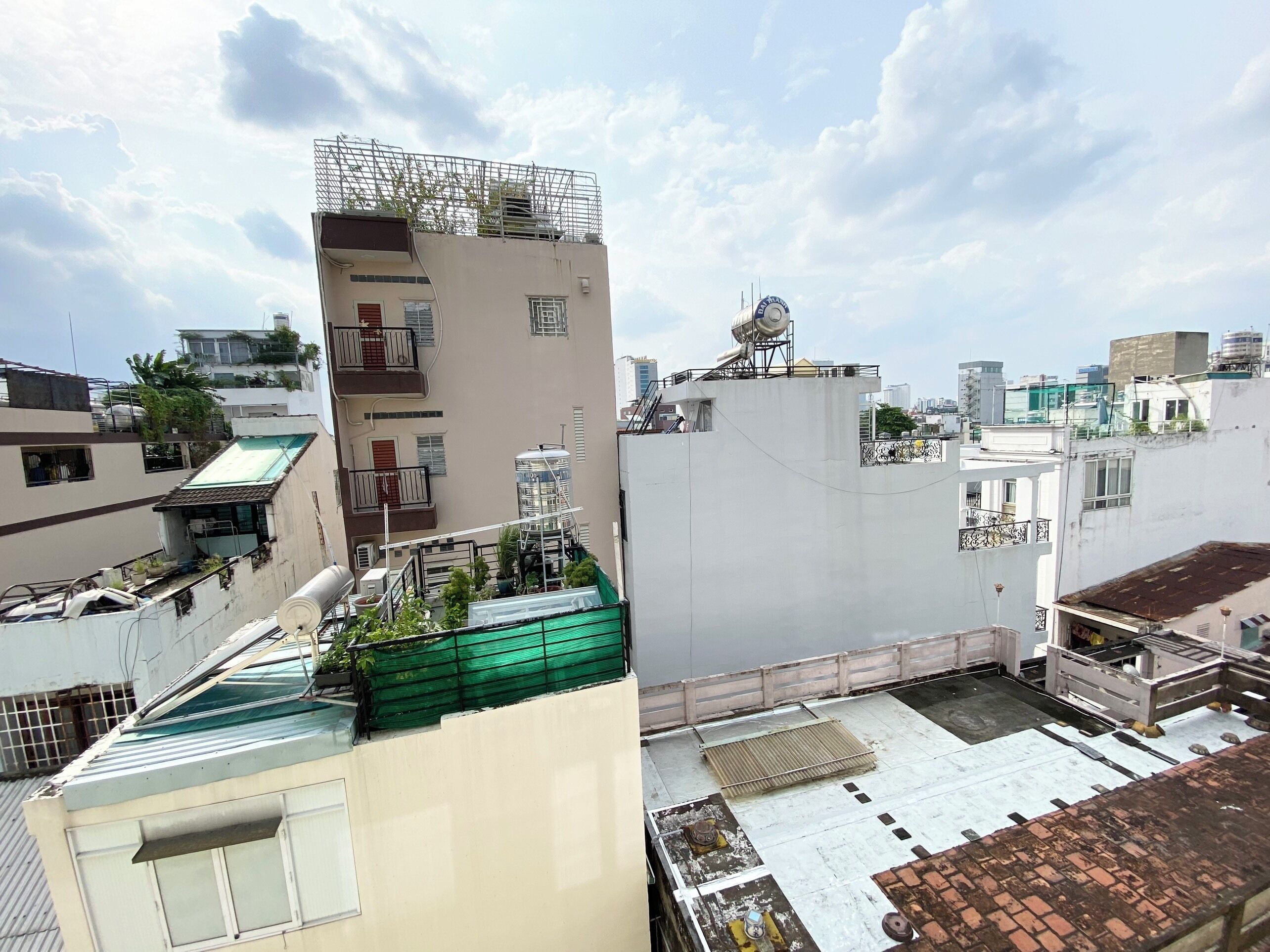 A multi-story building with a rooftop terrace, a water tank, and a satellite dish.