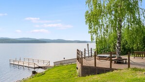 A lakeside park with a wooden deck, a rope barrier, and a birch tree. - Vacation home Kaisla by Interhome (Joensuu)