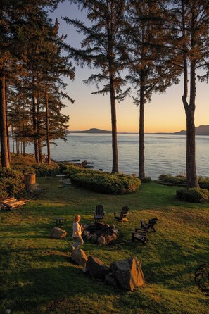 A serene lakeside setting with a fire pit, outdoor seating, and a view of the water. - Waterfront Retreat w/ Sauna | Whales & Sunrises (Friday Harbor)
