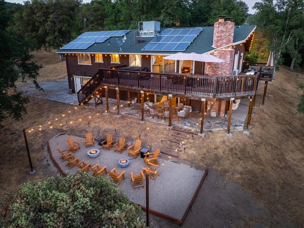Ein Haus mit Terrasse, Sitzgelegenheiten im Freien und Solaranlage.