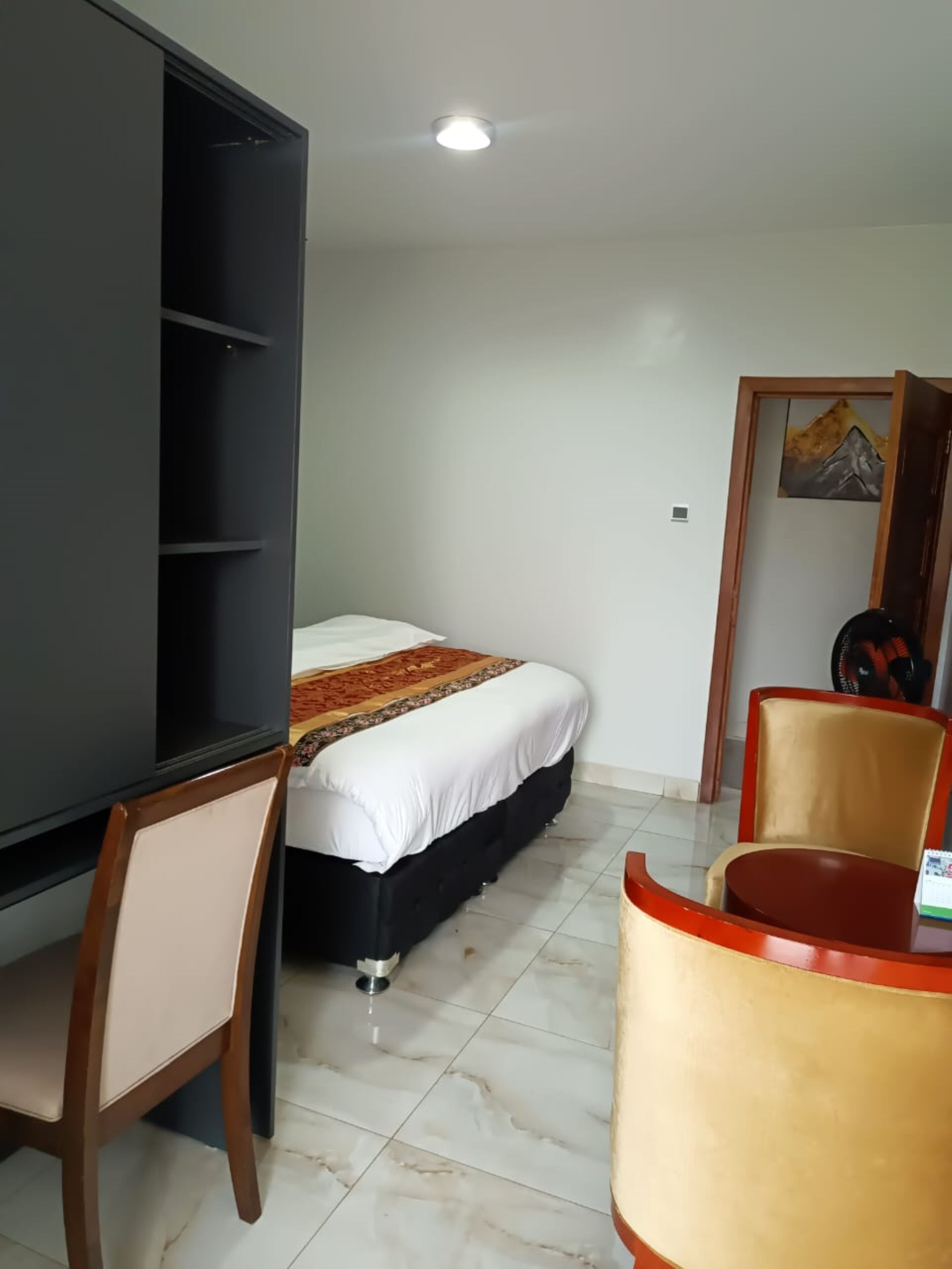 Une chambre d’hôtel avec un lit, un bureau, une chaise et une petite table.