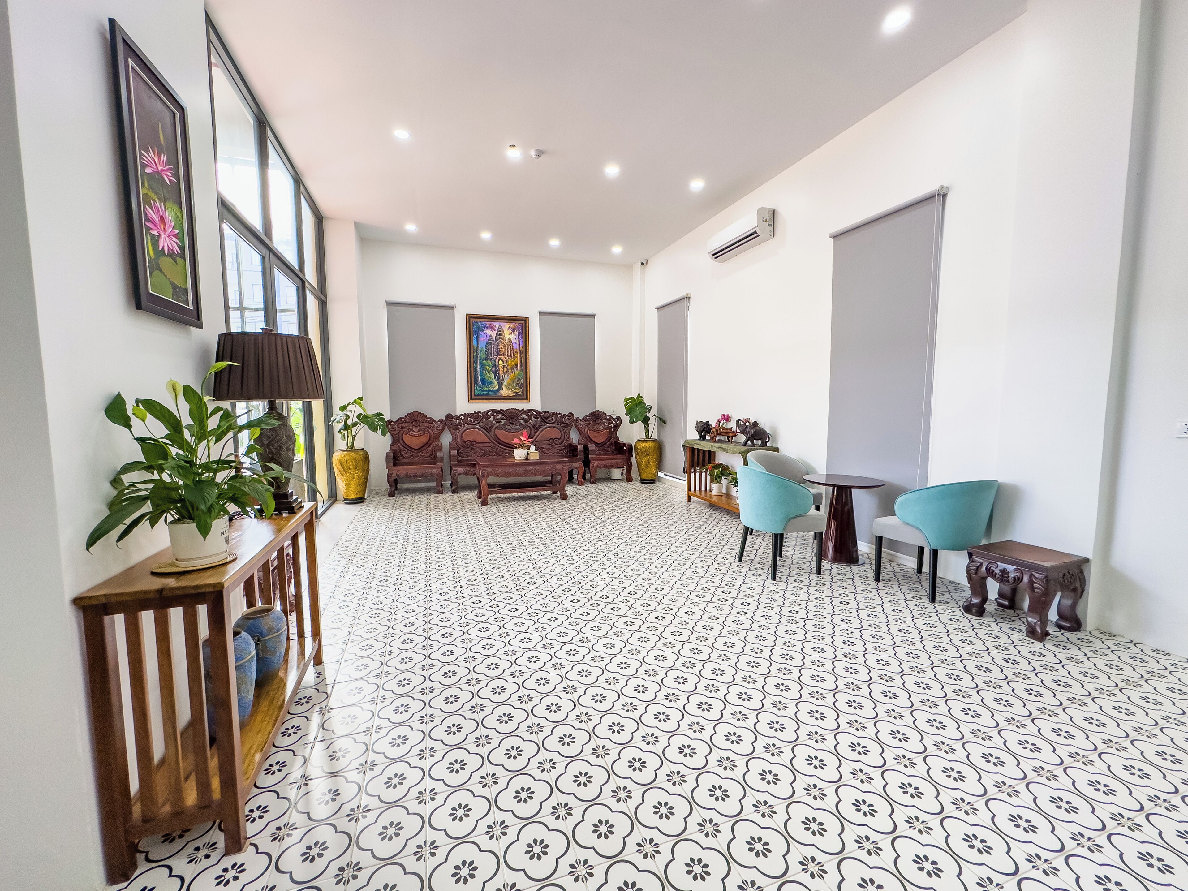 A spacious living room with a patterned floor, a sofa set, a coffee table, and a TV.