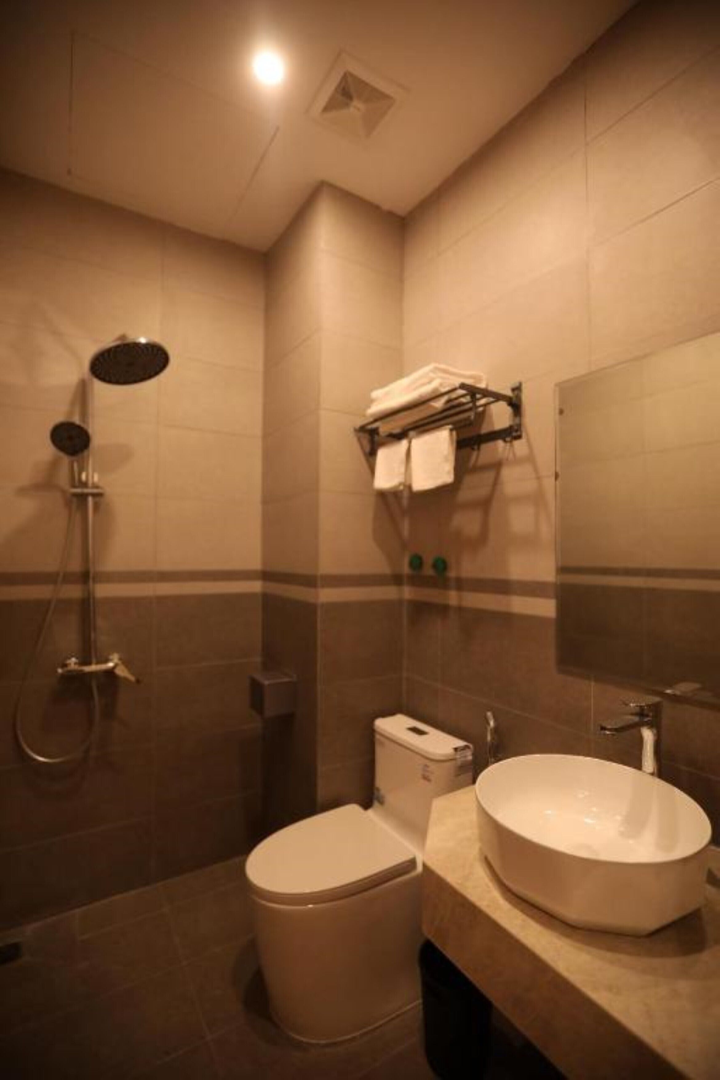 A bathroom with a toilet, sink, and shower.