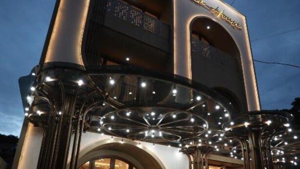 Ein Hotel Eingang mit modernem Design, gekennzeichnet durch ein markantes Bogenportal und beleuchtete Beschilderung.