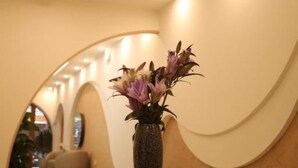 Ein modernes Interieur mit einem runden Tisch, einer Blumenvase und einer gewölbten Wand.