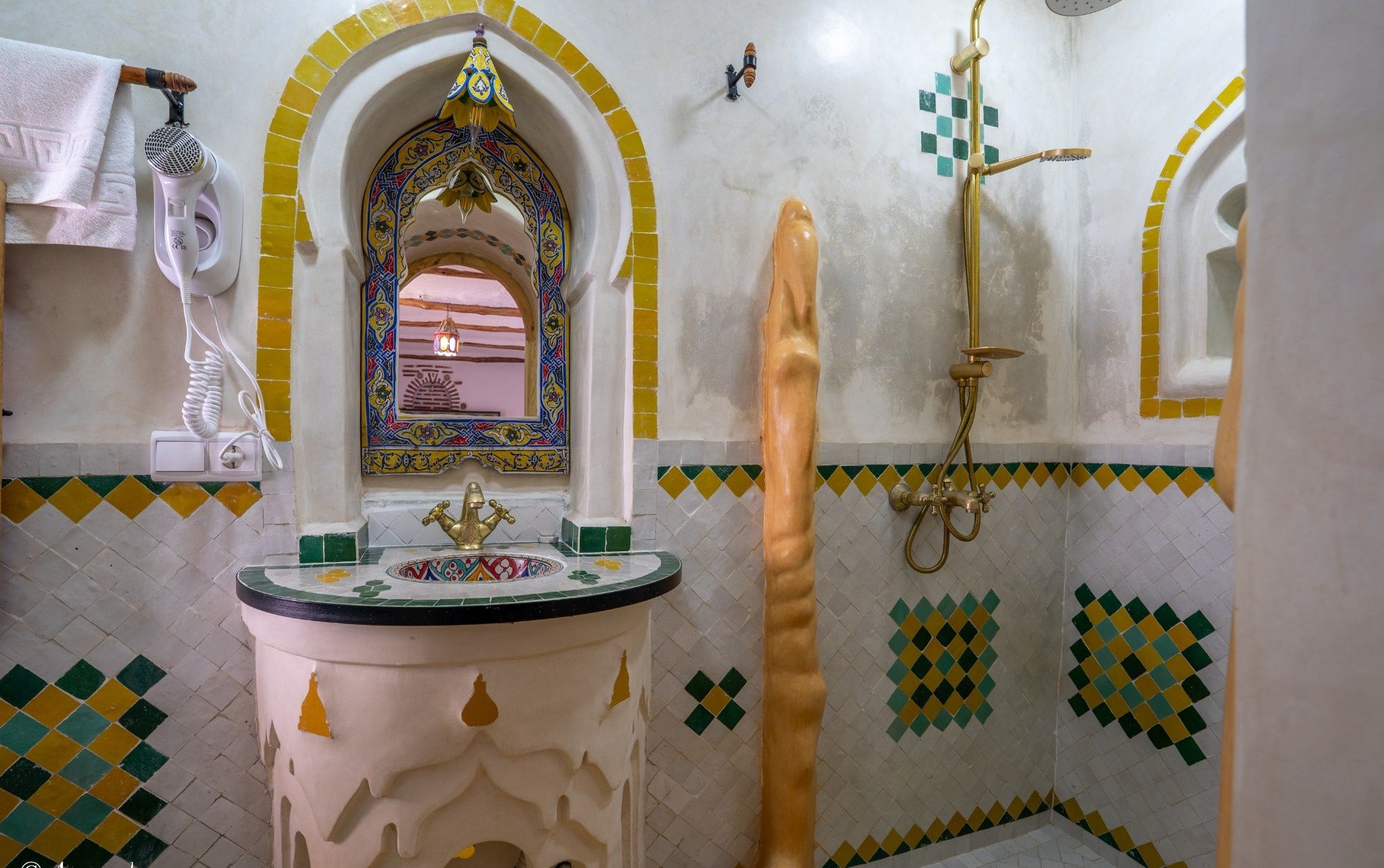 A bathroom with a sink, mirror, and shower.