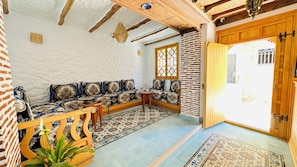 Traditional interior with a wooden bench, table, and patterned rug.