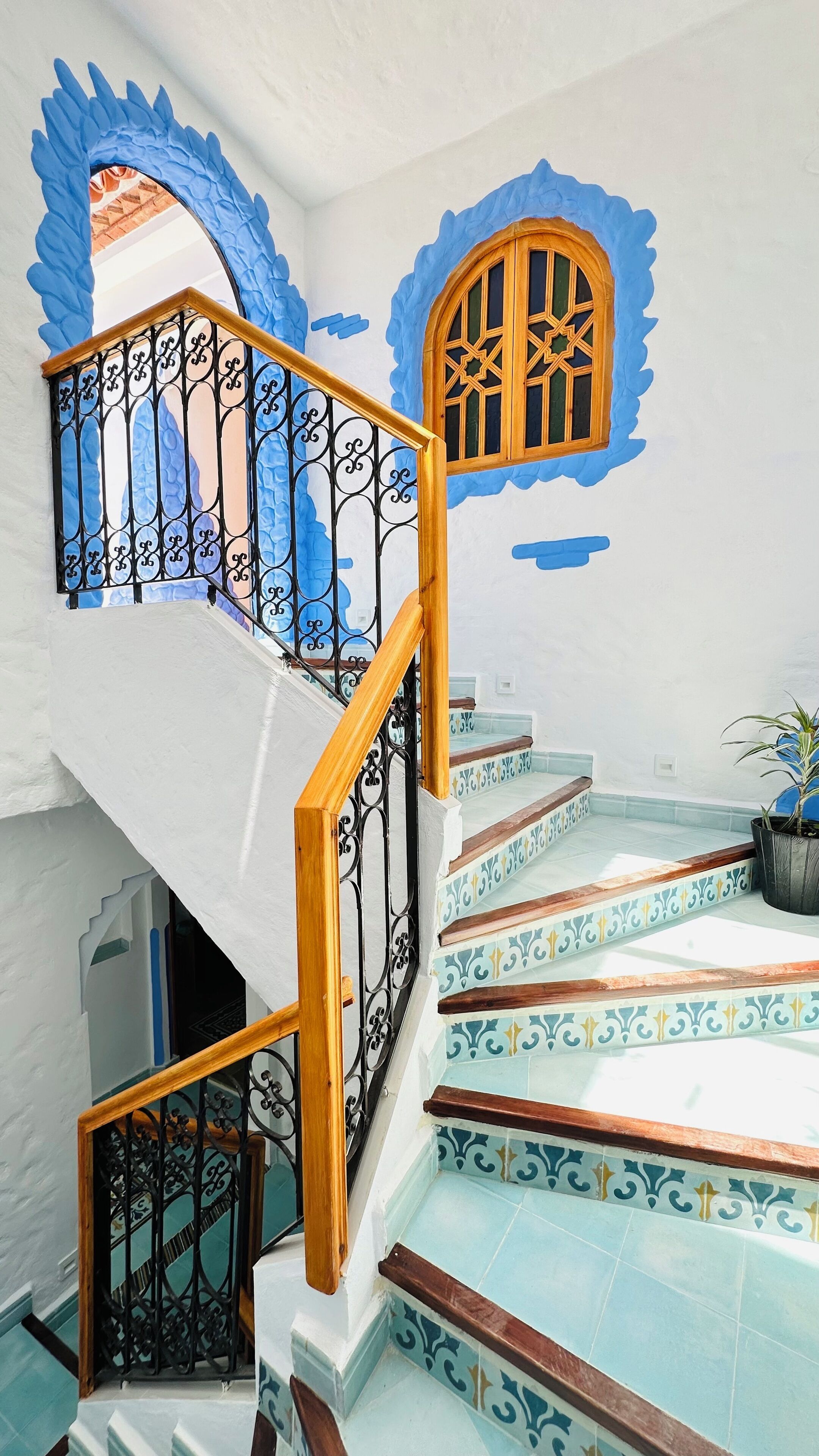 A staircase with ornate railings and patterned tiles.